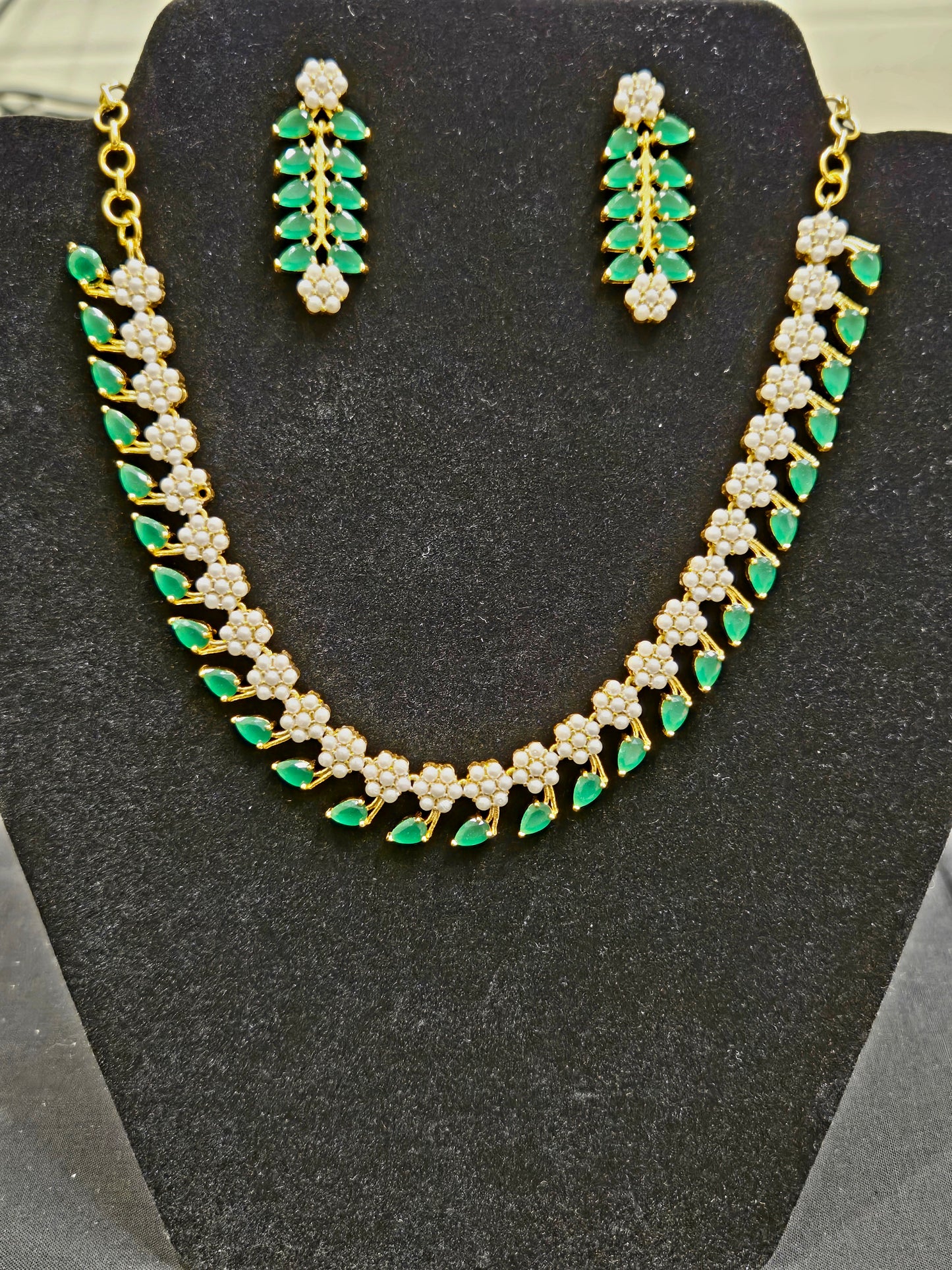 Stunning  Emerald Stone Studded Leaf Shaped Gold Plated Necklace Set With Pearls And Earring