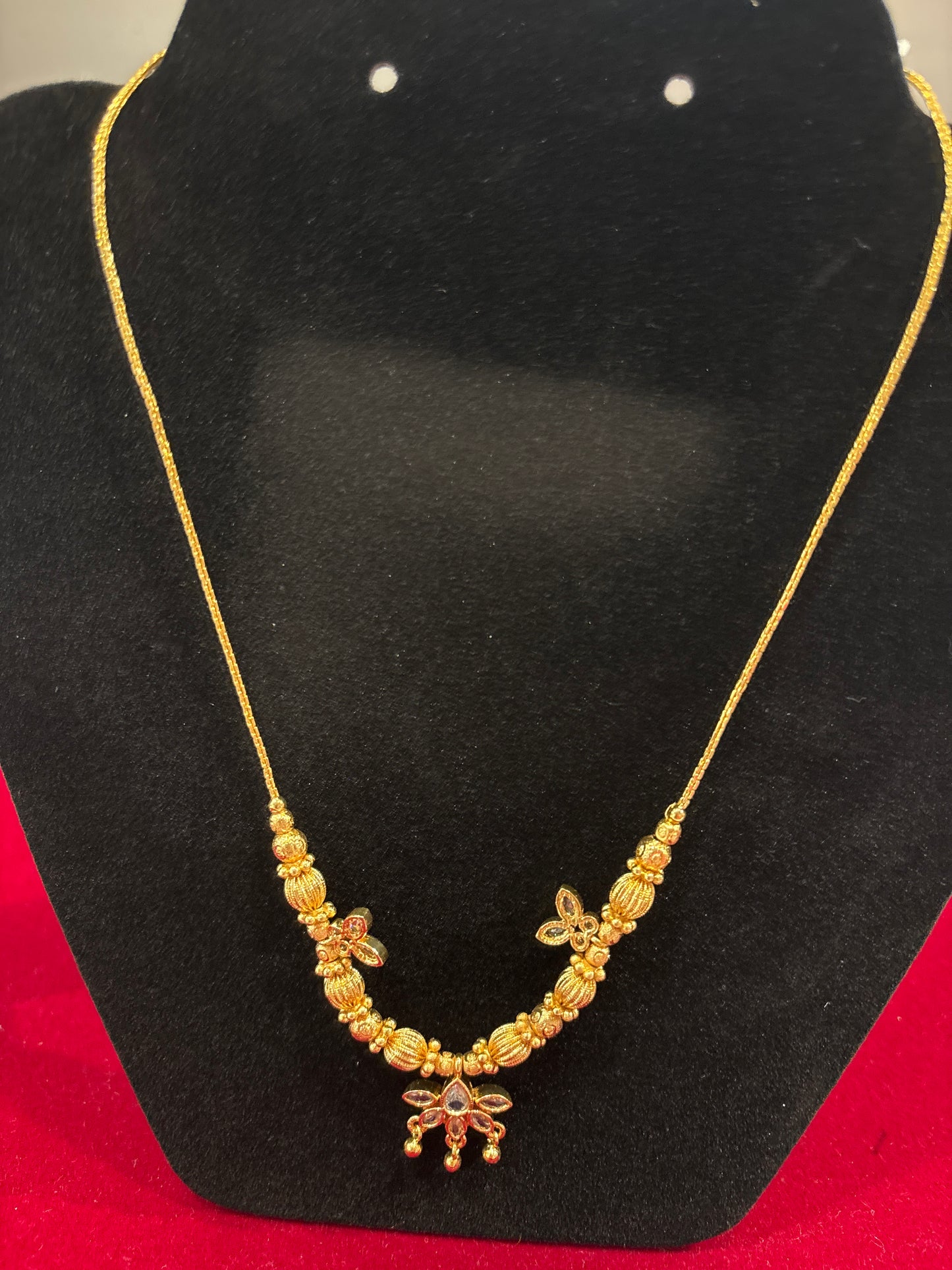 Charming Gold Necklace With Fluted Beads and A White Gemstone Flower Pendant