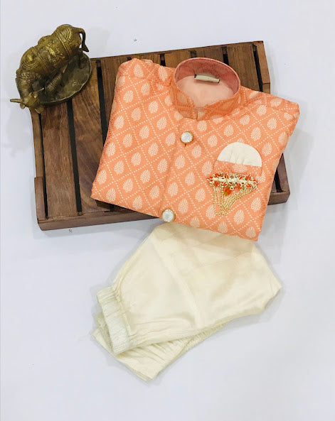 Pretty Orange Colored Kids Sherwani With Brooch Pin Pearl Mala And Juttis