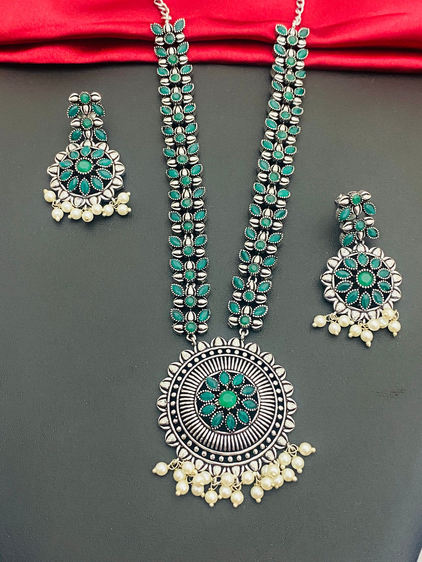 Alluring Emerald Stoned Leaf Design Silver Oxidized Necklace With Daisy Dollar And Matching Earrings