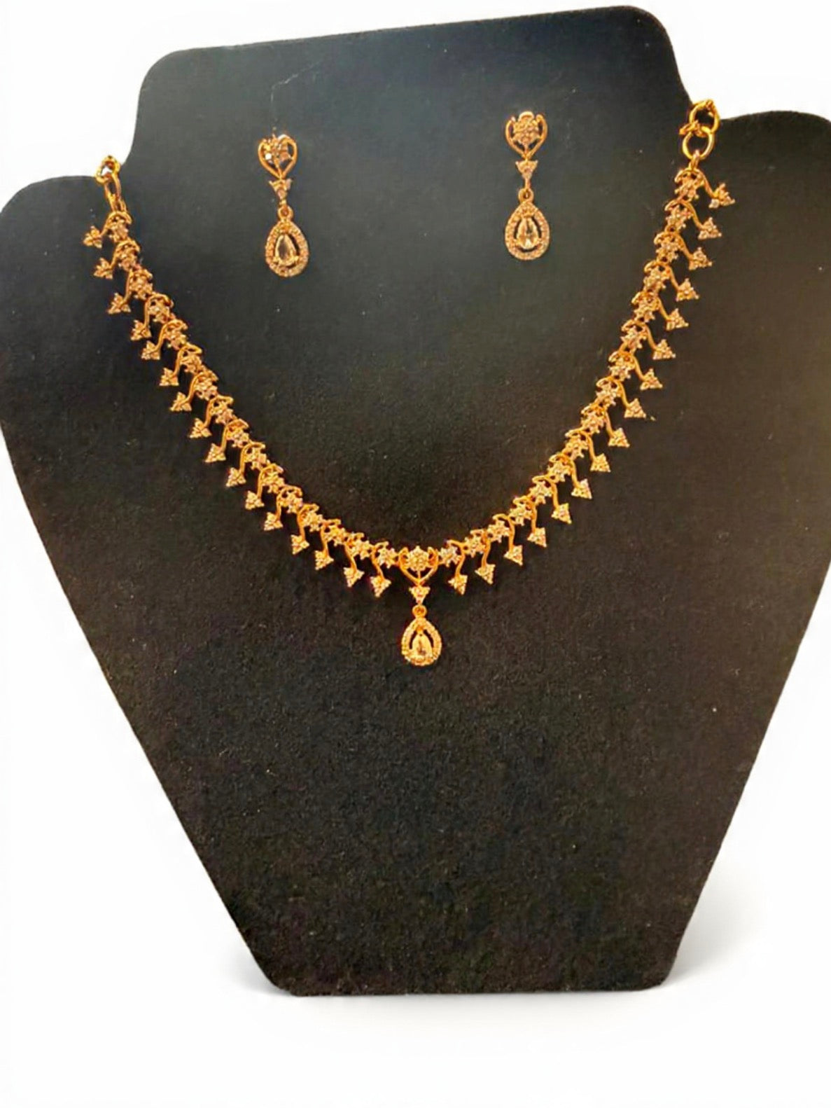 Beautiful gold plated flower pot shaped necklace with white stones.