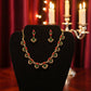 Pretty gold plated curved necklace set with green, red and white stones.